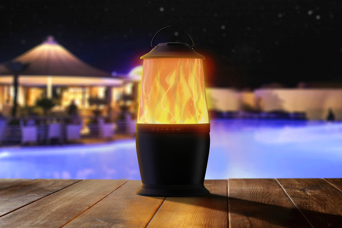 OKKO Ember Portable Bluetooth Speaker next to a pool at night showing illuminated speaker