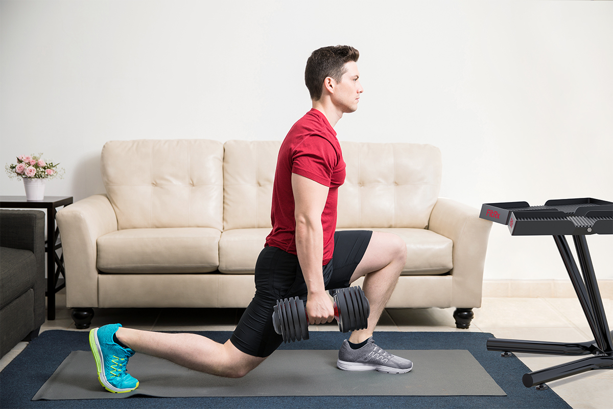 Man using FitRx SmartBell Adjustable Dumbbells at home
